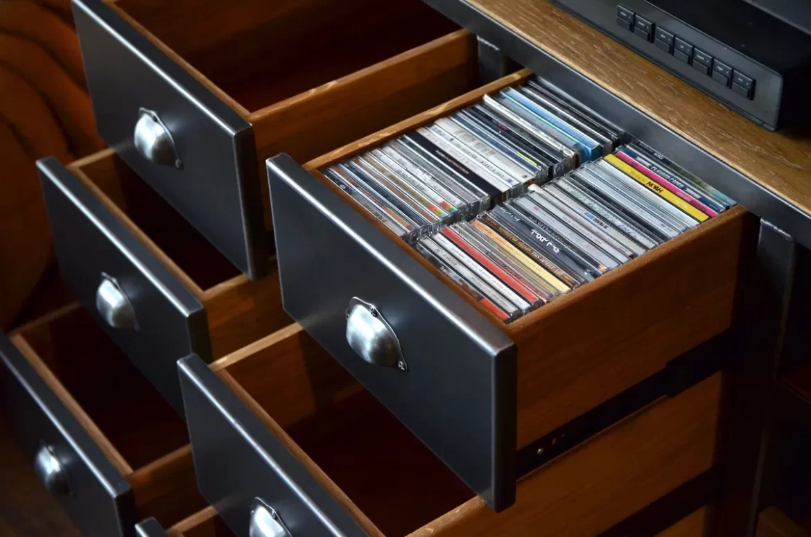 Meuble sur mesure en bois avec tiroirs à poignées métalliques pour rangement de CD, illustrant la fabrication à la commande