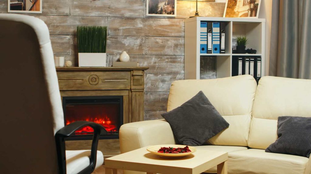 Un salon chaleureux doté d'une cheminée moderne et d'un canapé confortable, idéal pour illustrer quel est le chauffage le plus économique pour grande maison
